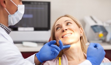 woman is chair smiling during dental appointment