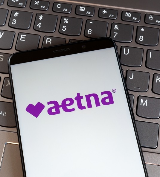 Phone with Aetna logo lying on keyboard