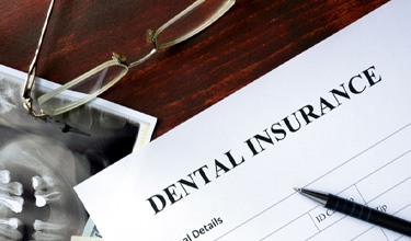 dental insurance claim form on a clipboard with a pen on it