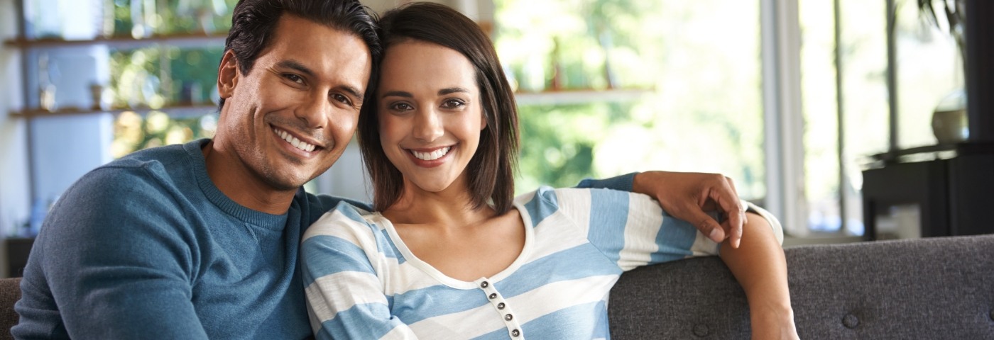 Man and woman sitting on couch and smiling
