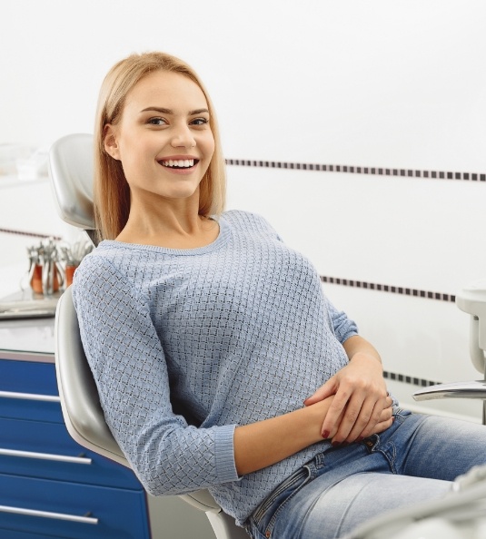Woman sitting in dental chair and smiling