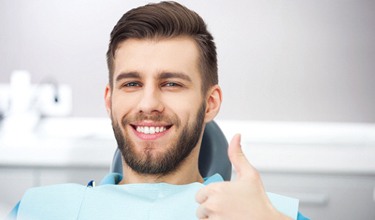 Man giving a thumbs up after getting a dental crown in Carrollton