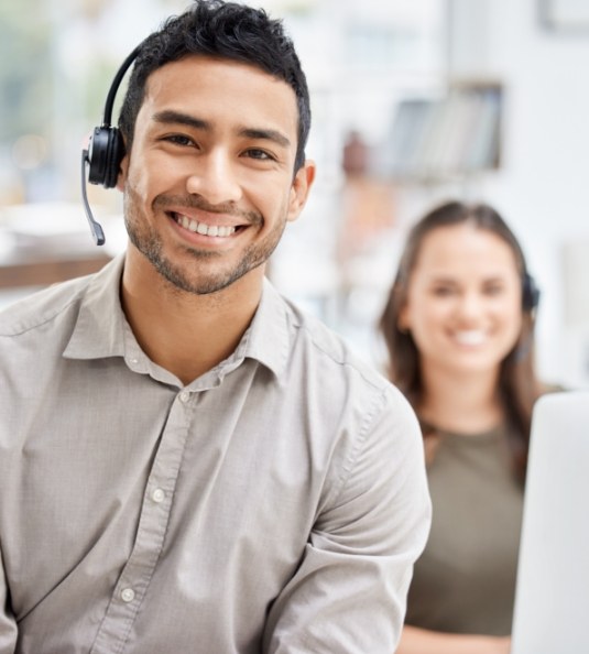 Man with headset sitting and smiling