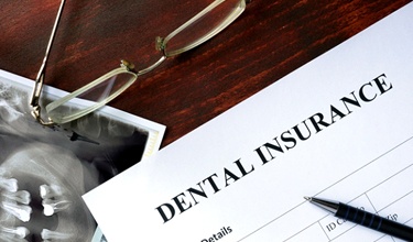 a dental insurance claim form with a pen sitting on top of it