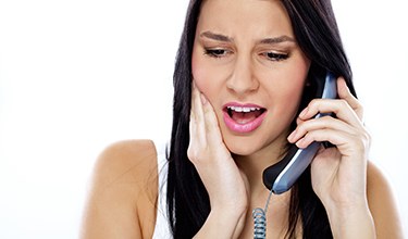 Woman with toothache calling her Carrollton emergency dentist