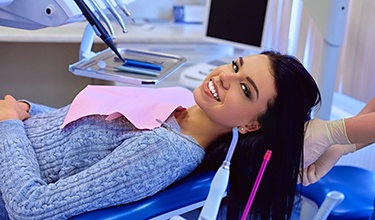 Woman smiling while visiting a dentist in Carrollton