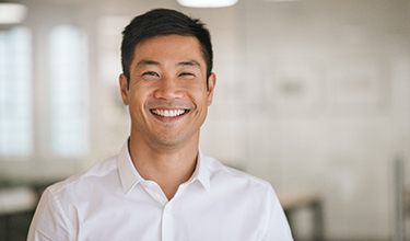 Man with white shirt smiling in office building