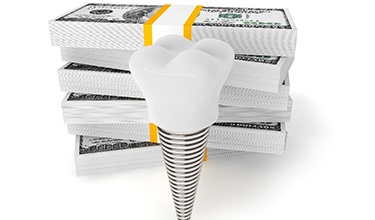 Model dental implant and stacks of money representing the cost of dental implants in Carrollton 