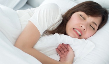 A woman clenching her teeth in her sleep.