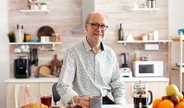 a person drinking coffee and eating breakfast in their kitchen