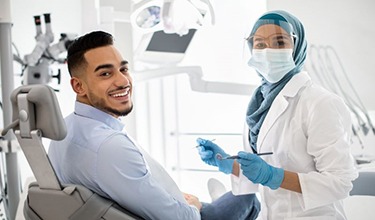 Smiling dental patient looking over his shoulder
