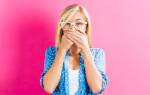 young woman covering mouth