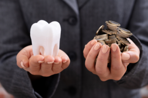 Hands holding coins and molar