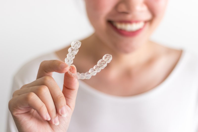 person holding Invisalign aligner