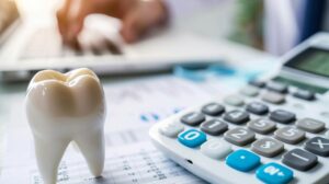 Close-up of tooth model next to calculator