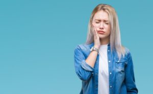 Woman holding jaw in pain. 